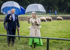 Máxima draagt een wel héél bekende groene jurk tijdens een regenachtig werkbezoek