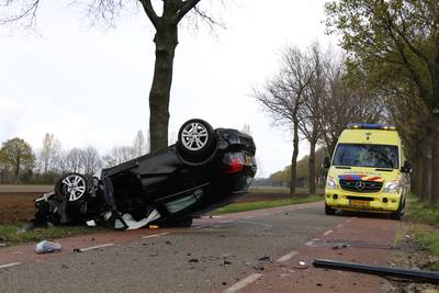Auto tegen boom en op de kop bij Wanroij