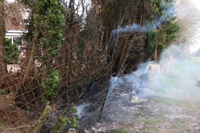 Bewoner en voorbijganger blussen brand in haag met slootwater in Groessen