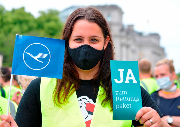 Een werknemer van Lufthansa demonstreert in Berlijn. 'Ja aan het reddingspakket' staat er op het bordje geschreven.