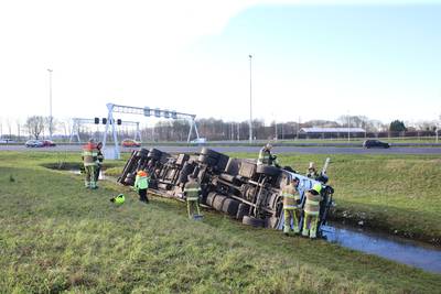 Vrachtwagen belandt op zijn kant in de sloot bij afrit A2