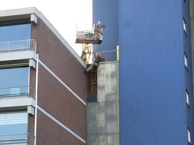 Harde wind rukt gevelplaten van flat aan Zuiderkruis