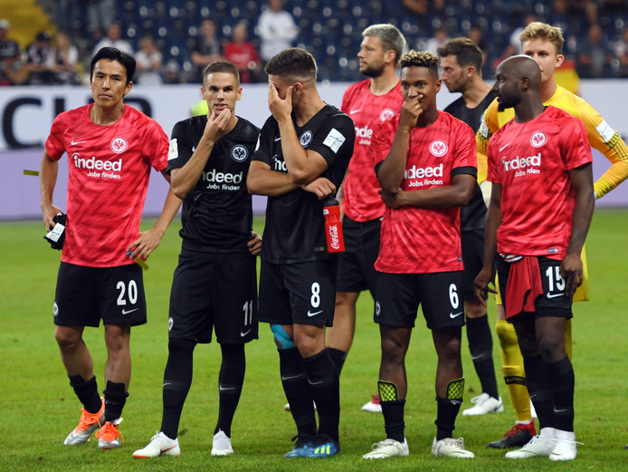 Jetro Willems,Jonathan de Guzmán en hun teamgenoten van Eintracht Frankfurt treuren na de flinke nederlaag.