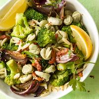 Pittige lentewok met orzo, spek en tuinbonen