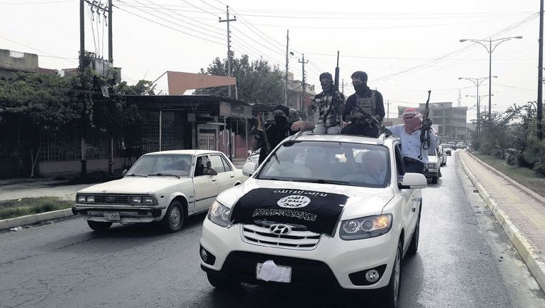 Strijders van Isis rijden in Mosoel in auto's van de Iraakse veiligheidstroepen die ze buit hebben gemaakt bij de inname van de stad. Beeld reuters