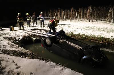 Auto vliegt uit de bocht en komt op de kop in volle sloot terecht