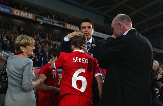 Carol en Roger Speed met hun kleinzonen Ed en Thomas tijdens de Gary Speed Memorial-wedstrijd begin 2012 tegen Costa Rica. In het midden bondscoach Chris Coleman.