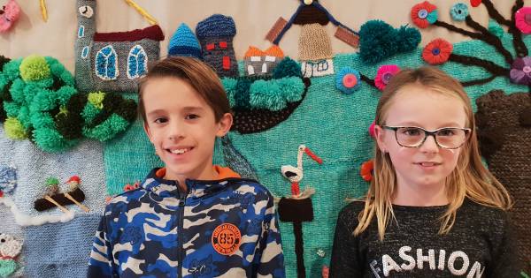 Jong en oud punnikt, breit en haakt Dussens wandkleed