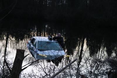 Auto mist voetgangers rakelings en rijdt water in