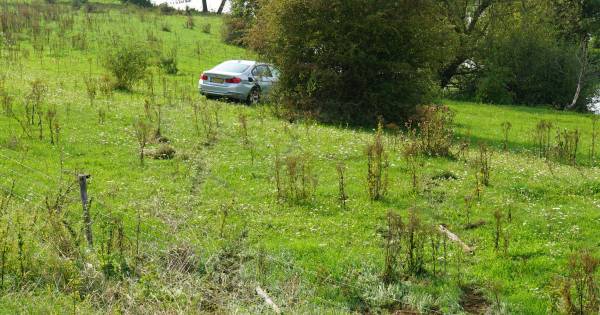 Motorrijder en automobilist botsen hard tegen elkaar: wagen in weiland