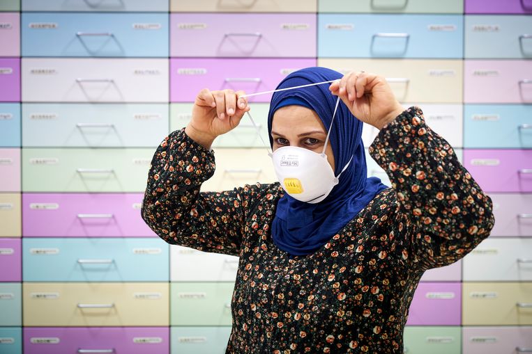 Een werknemer van de apotheek demonstreert een mondkapje.  Beeld ANP