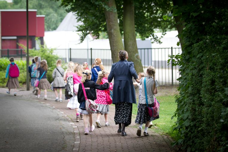 Moeders brengen kinderen naar de reformatorische basisschool Eben-Haezer in Barneveld. Barneveld is onderdeel van de biblebelt waar het nieuwe coronavirus zich snel verspreidt.  Beeld ANP